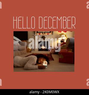 Komposition von Hello-dezember-Text über afroamerikanisches Mädchen zu weihnachten Stockfoto