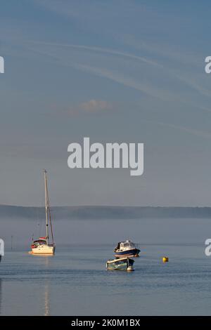 Am frühen Morgen ist Nebel und Freizeitboote im Hafen von Poole verankert Stockfoto