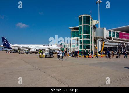 Passagiere auf Asphalt neben einem Lufthansa airbus-Flugzeug am Flughafen Porto in Portugal. Stockfoto