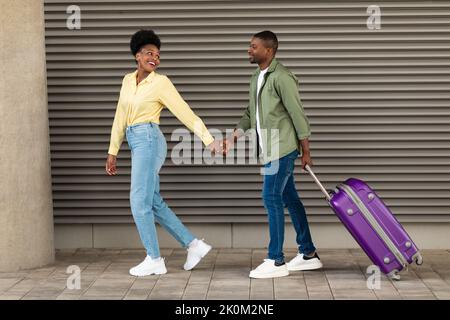 Glückliche Afroamerikanische Touristen Gehen Mit Koffern Im Freien Stockfoto