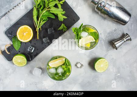 Erfrischender alkoholischer Cocktail Mojito im Sommer mit Eis, frischer Minze und Limette. Draufsicht. Stockfoto