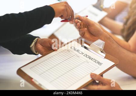 Das Zurückgeben ist so lohnend. Freiwillige Unterschriften für Kirchenspenden zu erhalten. Stockfoto