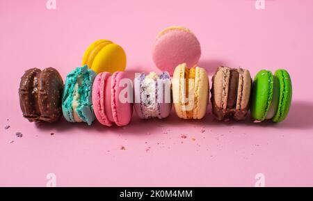 Helle bunte verschiedene Geschmack Macarons süße Kekse auf rosa Hintergrund. Stockfoto