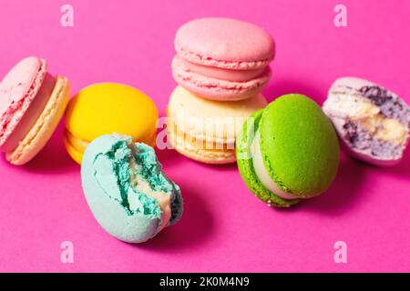 Helle bunte verschiedene Geschmack Macarons süße Kekse auf hochfarbigem rosa Hintergrund. Stockfoto