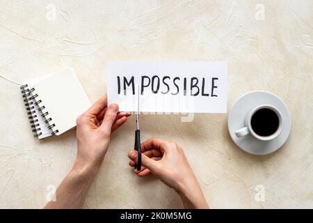 Es ist möglich Konzept. Mit einer Schere wird das Wort unmöglich möglich Stockfoto