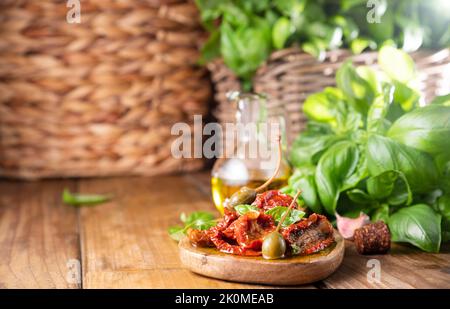 Getrocknete Tomaten mit Kräutern und Olivenöl. Traditionelle Tomaten aus der Dose in Italien mit Knoblauch, Kräutern der Provence und Basilikum. Zutaten für Bruschetta und Aperitif. Draufsicht, Platz für Text Stockfoto