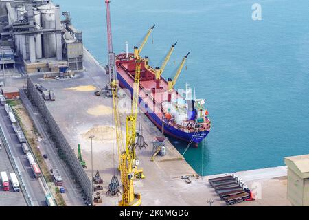 Hafen von Barcelona, Spanien, 25. August 2022: Schiff mit Rohstoffen wird im Hafen von Barcelona entladen. Stockfoto