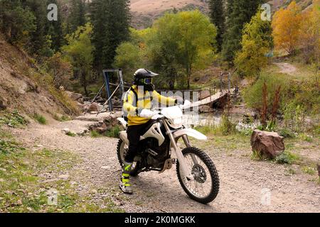 Ein Typ auf einem Motorrad in den Bergen im Herbst Stockfoto