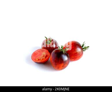 Runde violett-rote Tomaten, ganze und halbe auf weißem Hintergrund. Stockfoto