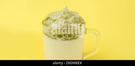 Dalgona Matcha Latte, gelber Hintergrund. Matcha grüner Tee. Selektiver Fokus. Speicherplatz kopieren Stockfoto