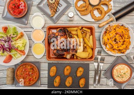 Rezepte für Gerichte und Tapas mit Kroketten verschiedener Geschmacksrichtungen, Thunfischsalat mit Tomaten und Zwiebeln, Hühnchen vom Holzkohlegrill, Krautsalat, gerösteter roter Pep Stockfoto