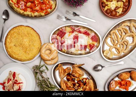 Rezepte spanischer Gerichte und Tapas mit Kroketten verschiedener Geschmacksrichtungen, Salat mit Ventresca, andalusischer Tintenfisch, Kartoffelomelett, madrilenische Patatas b Stockfoto