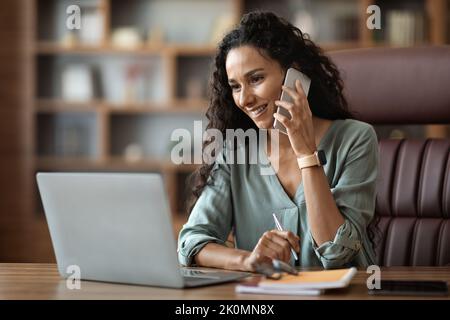 Attraktive junge Unternehmerin mit Telefongespräch Stockfoto