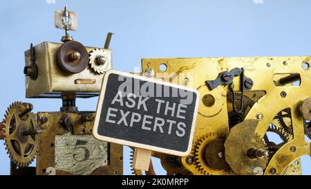 Roboter mit Zahnrad hält Platte Fragen Sie die Experten. Stockfoto
