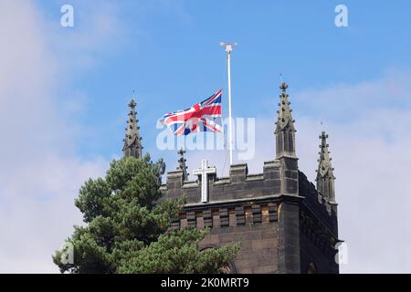 St Mary's Church in Svillington, Leeds, Großbritannien, die die Unionsflagge am halben Mast in Trauer um den Tod von Königin Elizabeth II. Fliegt Stockfoto