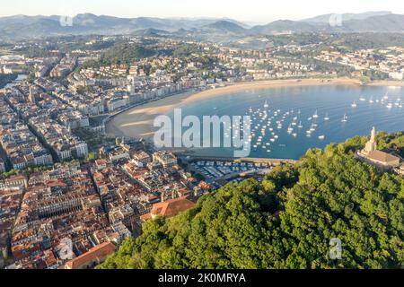 Luftperspektive von Donostia - San Sebastian Stadt. Panoramablick auf die Stadt bei Sonnenaufgang. Blick auf die Stadt und die Bucht von La Concha. Stockfoto