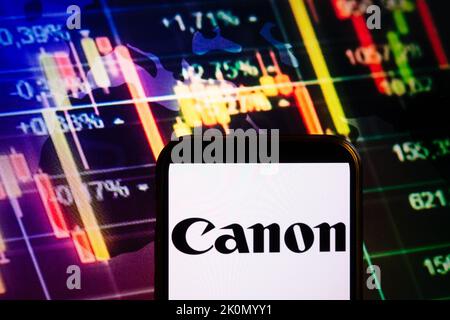 KONSKIE, POLEN - 10. September 2022: Smartphone mit Logo der Firma Canon auf dem Hintergrund des Börsendiagramms Stockfoto