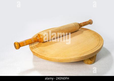 Roti oder Brotschneiden und Flatting Board mit Nudelholz für selbstgebackenes Backen auf weißem Hintergrund. Stockfoto