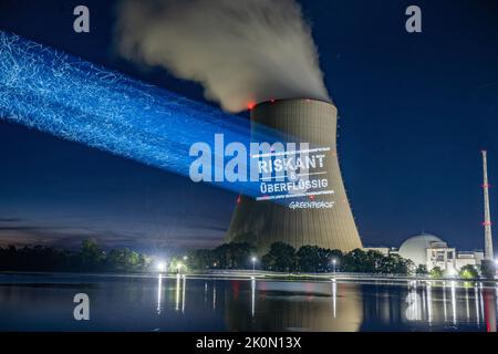 Essenbach, Deutschland. 12. September 2022. Greenpeace-Aktivisten projizieren „riskant & unnötig“ auf den Kühlturm des Atomkraftwerks Isar 2. Quelle: Armin Weigel/dpa/Alamy Live News Stockfoto