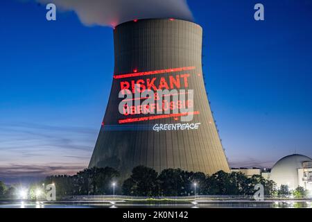 Essenbach, Deutschland. 12. September 2022. Greenpeace-Aktivisten projizieren „riskant & unnötig“ auf den Kühlturm des Atomkraftwerks Isar 2. Quelle: Armin Weigel/dpa/Alamy Live News Stockfoto
