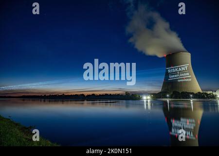 Essenbach, Deutschland. 12. September 2022. Greenpeace-Aktivisten projizieren „riskant & unnötig“ auf den Kühlturm des Atomkraftwerks Isar 2. Quelle: Armin Weigel/dpa/Alamy Live News Stockfoto