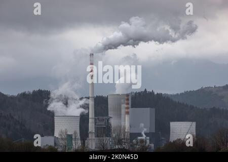 Grauer Himmel und giftige Emissionen, die aus einem Kohlekraftwerkskamin freigesetzt werden. Energiewirtschaft, Umwelt- und Gesundheitskonzept. Stockfoto