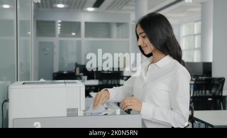 Arabisch hispanische Geschäftsfrau Mädchen Arbeiter Sekretärin macht Kopien auf Kopierer verwenden Büroausstattung Druckmaschine replizieren Papiere senden Fax drucken Stockfoto