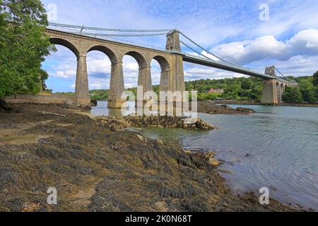 Die Menai Suspension Bridge von Thomas Telford, Pont Menai, von der Menai Strait, Menai Bridge, Isle of Anglesey, Ynys Mon, North Wales, VEREINIGTES KÖNIGREICH. Stockfoto