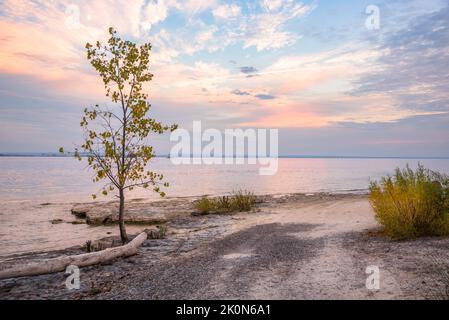 Majestätischer Herbstuntergang über einem leeren Strand an einem See im Herbst Stockfoto