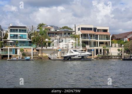 Brisbane, Queensland, Australien - September 2022: Luxushäuser am Flussufer mit eigenem Bootssteg. Blick auf den Fluss, teurer Lebensstil für die Stockfoto