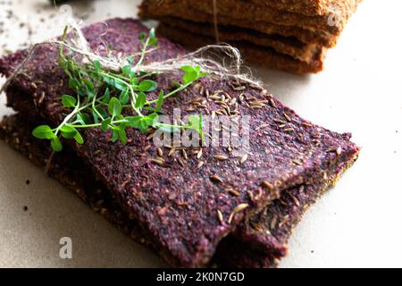 Dehydrierte fettarme glutenfreie Lebensmittel mit Micro Greens. Hergestellt aus Leinsamen und Algen, Karotten und Buchweizen, Rüben und Sonnenblumenkernen. Brot essen. Nahaufnahme. Gesundes Ernährungskonzept. Rohe Lebensmittel. Stockfoto