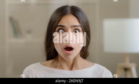 Emotional shocked brunette arab woman stressful frightened scared hispanic girl lady lost hold head with hands feel horror shock receive bad news Stockfoto