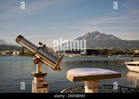 Teleskop am Flussufer in einer bergigen Stadt Stockfoto