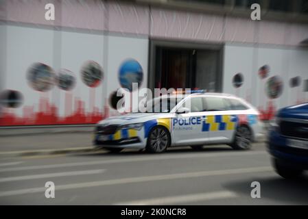 Ein Polizeiauto mit blinkenden Lichtern und Sirenen, die heulen, führt zu einem Notfall in Christchurch, der Quake City von Neuseeland. Das Bild ist radial verzerrt Stockfoto