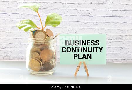 Schwarze Pancel schreiben einen Text BUSINESS CONTINUITY PLAN auf den gelben HINTERGRUND. Stockfoto