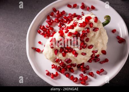 Chile en Nogada, typisches Gericht aus Mexiko. Zubereitet mit Poblano-Chili, gefüllt mit Fleisch und Früchten und bedeckt mit einer speziellen Walnusssauce. Benannt als Stockfoto