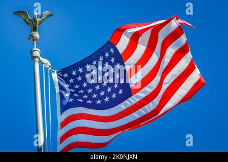 Amerikanische Flagge weht auf blauem Himmel am Halbmast in New York, september 11, USA Stockfoto