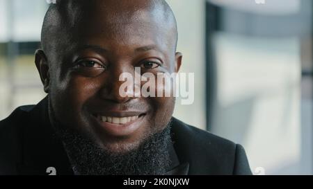 Glücklich zufrieden froh afroamerikanischen männlichen Geschäftsmann plus Größe Gesicht bärtig erwachsenen Mann mit dunkler Haut Mitarbeiter Erzieher lächelnd weiß gesund Stockfoto