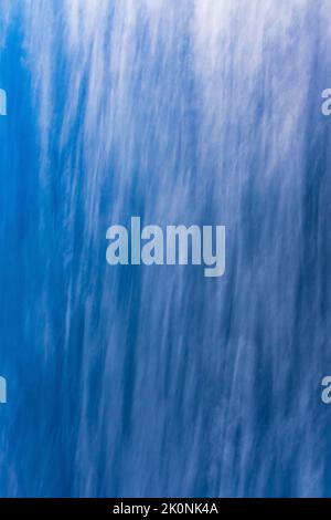 Weiße, wispige Wolken bilden ein abstraktes Muster am blauen Himmel Stockfoto