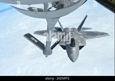 Ein F-22 Raptor mit dem Demonstrationsteam der Joint Base Langley-Eustis fliegt neben einem KC-135R Stratotanker mit dem 155. Air Betanking Wing, 25. August 2022, während einer Lufttankung. Die F-22-Piloten erhielten Treibstoff von der 173. Air Betanking Squadron, um anzukommen und sich auf ihre Flugshow in South Padre Island, Texas, vorzubereiten. (USA Air National Guard Foto von Senior Airman Alexander D. Schriner) Stockfoto