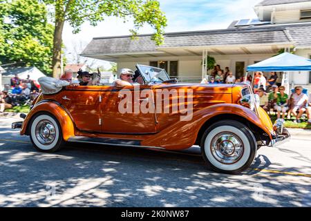 Ein orangefarbener 1934 Auburn 652Y Phaeton LF nimmt an der Auburn Cord Duesenberg Festival Parade 2022 in Auburn, Indiana, USA, Teil. Stockfoto