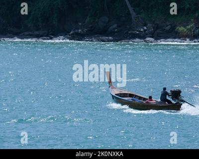 Fischerboote schwimmen auf dem Meer. Zwei Fischer in einem Boot segeln in den tropischen Meeren. Stockfoto