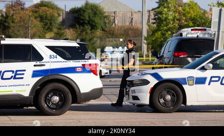 Mississauga, Kanada. 12. September 2022. Am 12. September 2022 wird ein diensthabende Polizeibeamter am Ort der doppelten Schießerei in Mississauga, im Großraum Toronto, Kanada, gesehen. Ein kanadischer Polizist wurde am Montag getötet und ein Verdächtiger befindet sich nach zwei Tageslichtschießereien in Toronto, der größten Stadt des Landes, in Haft, berichteten lokale Medien. Quelle: Zou Zheng/Xinhua/Alamy Live News Stockfoto