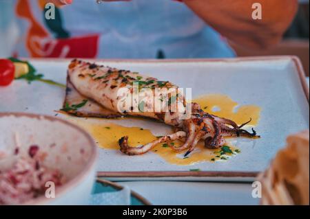 Im Restaurant wird Calamari auf dem Tisch serviert Stockfoto