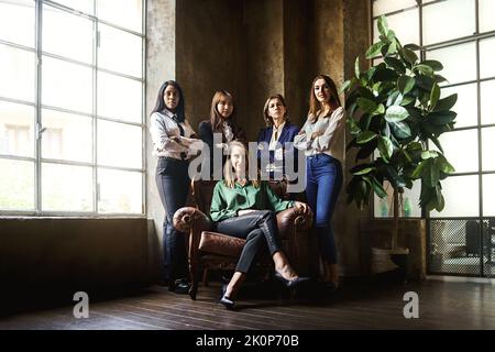 Unternehmensporträt einer Gruppe weibliche Geschäftsfrauen, die in den Büroarmen gekreuzt stehen - Business Co-Working erfolgreiches weibliches Team - nur multiethnisch Stockfoto