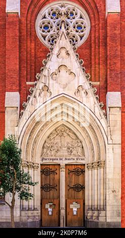Madrid, Spanien - 28. Juni 2021: Markante rot-weiße Ziegelfassade der Kirche des Heiligen Kreuzes aus dem 19.. Jahrhundert oder Parroquia de Santa Cruz Stockfoto
