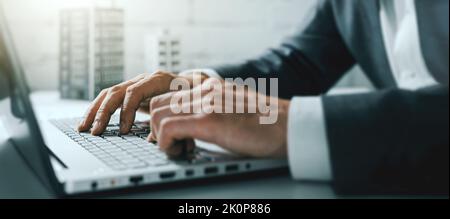 Nahaufnahme der Hände des Geschäftsmannes, die im Büro auf einem Laptop tippen. Banner Stockfoto