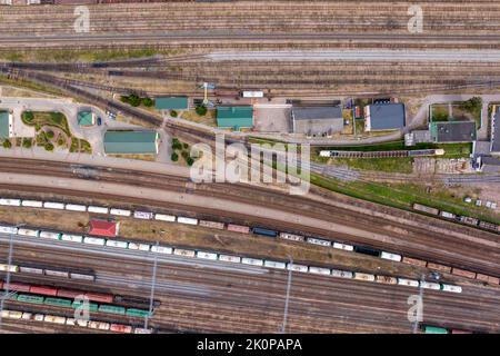 Luftaufnahme über lange Eisenbahngüterzüge mit vielen Waggons stehen auf dem Parkplatz Stockfoto