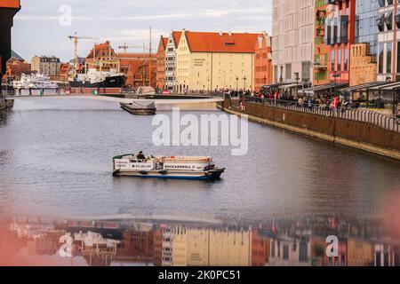 Danzig Polen Mai 2022 touristische Schifffahrt Altstadt in Danzig. Das Schiff mit Touristen fährt auf der Granary Island Reflection in Moltawa River Cityscap zu einer Kreuzfahrt am Flussufer ab. Uralter Kran. Besuchen Sie Danzig Poland Travel Destination. Touristenattraktion Stockfoto