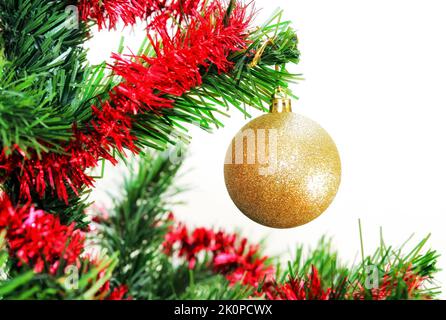 Rote weihnachtskugel auf geschmücktem weihnachtsbaum auf weißem Hintergrund Stockfoto